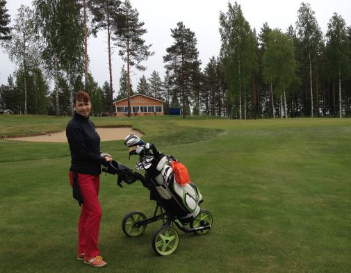 Mari Soisalo reiän 9 viheriön edustalla. Taustalla näkyy Puula Golfin klubirakennus.